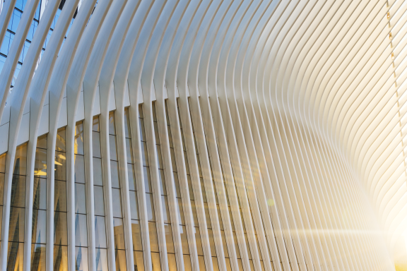 A modern building with tall louvred screens curving away