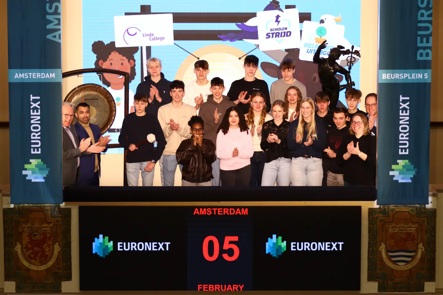 Winners of the BeleggerUitlegger schools investment competition autumn 2025 ring the Euronext Amsterdam gong, joined by their teachers and classmates.